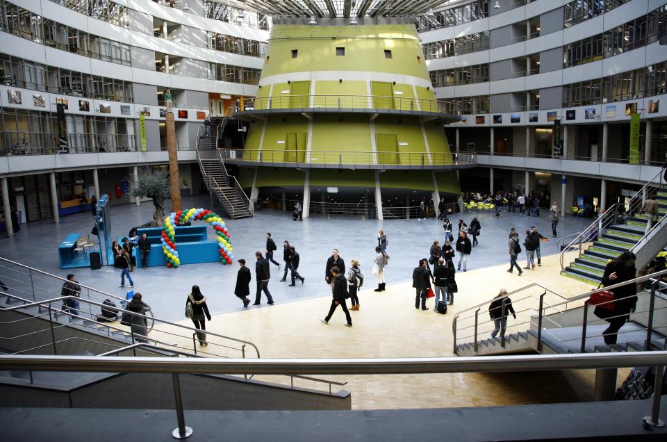Studenten lopen in tegengestelde richtingen door een zaal in de Haagse Hogeschool.