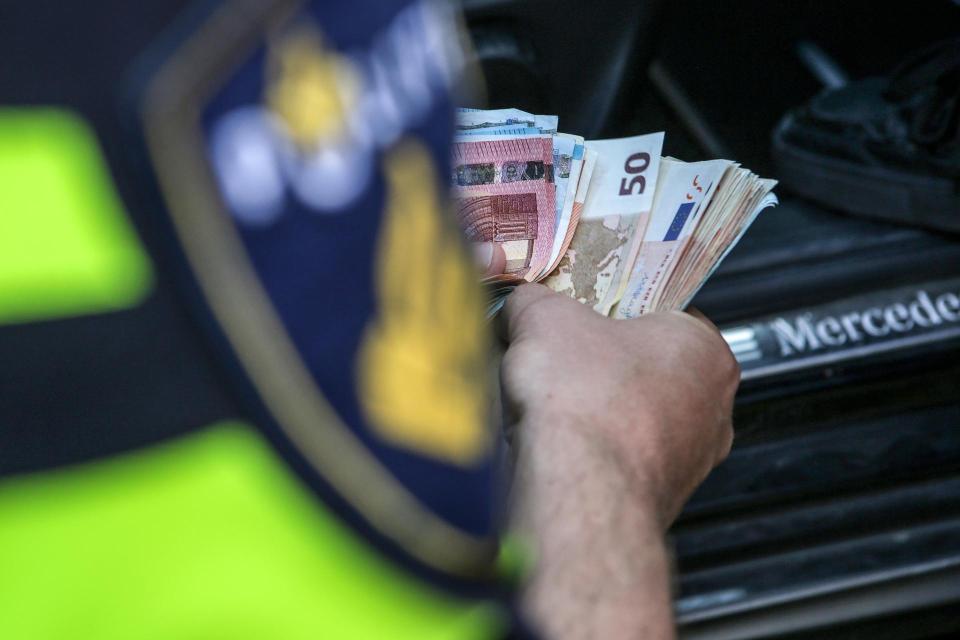 Agent telt geld dat werd gevonden bij een verkeerscontrole