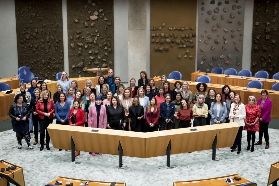 Vrouwelijke Kamerleden staan dichtbij elkaar op de foto in de plenaire zaal.