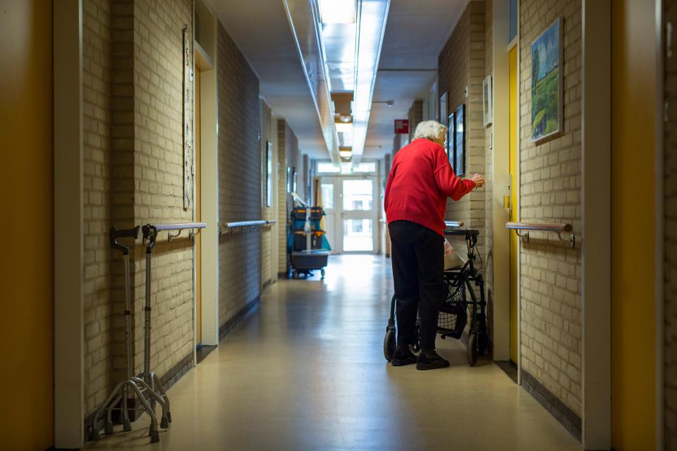 Bewoner loopt door de gang van een verpleeghuis