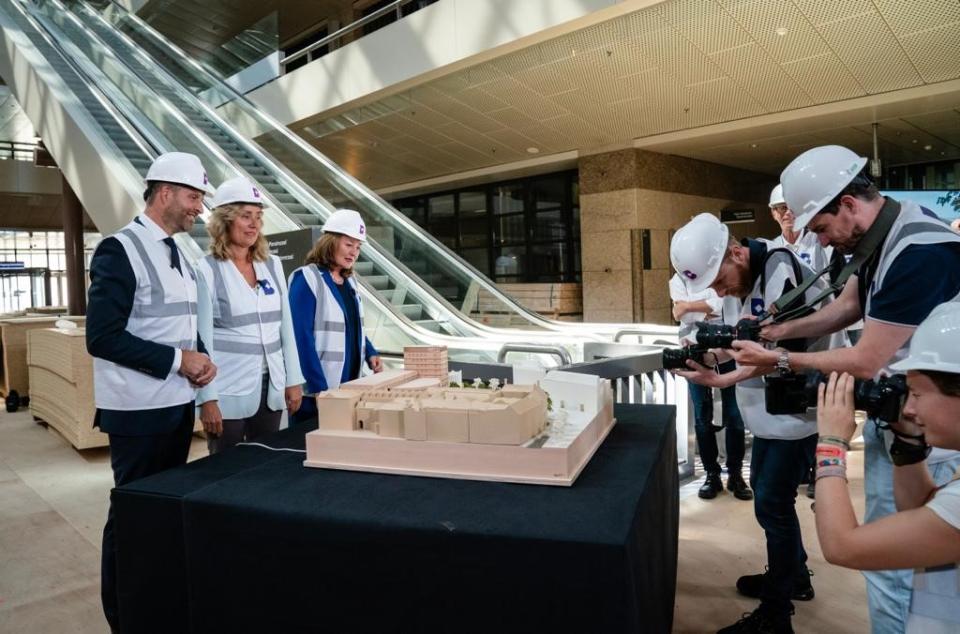 De maquette van de toekomstige publieksentree wordt gepresenteerd door Kamervoorzitter Vera Bergkamp, demissionair minister Hugo de Jonge en wethouder Saskia Bruines van de gemeente Den Haag. Zij staan in de Statenpassage van de Tweede Kamer aan het Binnenhof bij de roltrap en worden gefotografeerd.