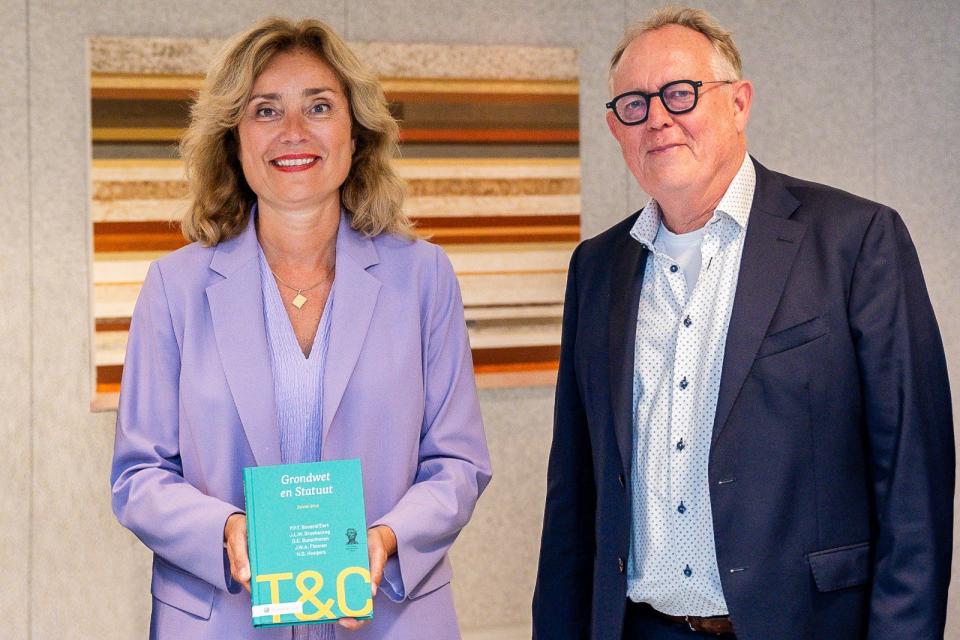 Kamervoorzitter Vera Bergkamp en hoogleraar Paul Bovend'eert staan naast elkaar, Bergkamp houdt het boek vast met de titel naar de kijker toe.. .jpg