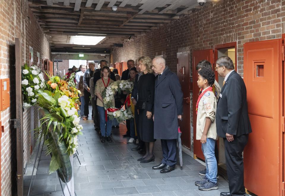 Voorzitter Vera Bergkamp van de Tweede Kamer, Voorzitter van de Eerste Kamer Jan Anthonie Bruijn en andere aanwezigen staan stil voor de krans bij Doodencel 601.