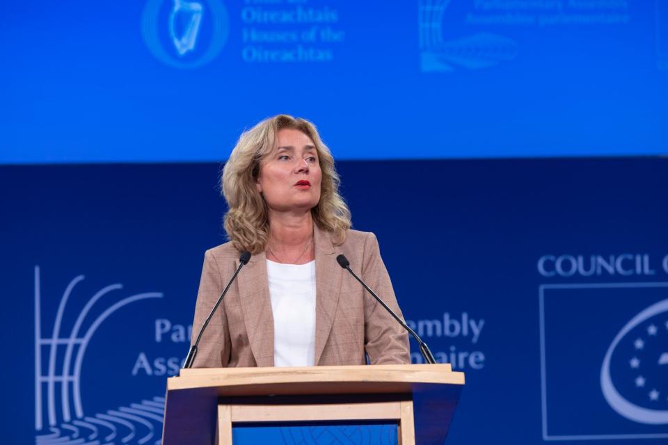Vera Bergkamp achter een katheder, zij houdt een speech