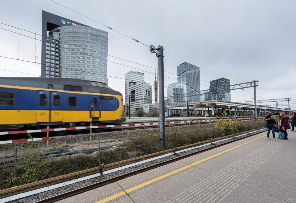 Geel-blauwe trein tussen de kantoren in Amsterdam-Zuid. 