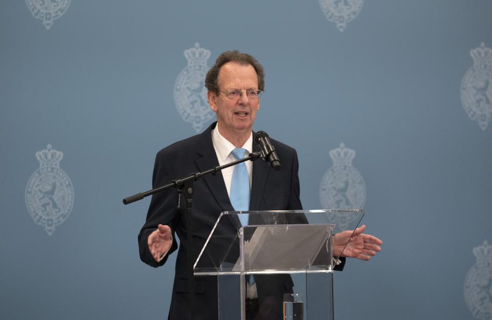 Verkenner Gom van Strien staat tijdens een persconferentie voor een microfoon en een katheder.
