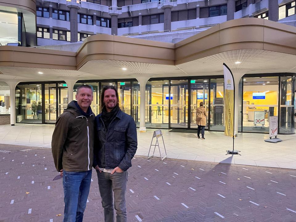 Twee personen, Steven en Benjamin, staan voor het gebouw van de Tweede Kamer, zij poseren voordat ze gaan stemmen.
