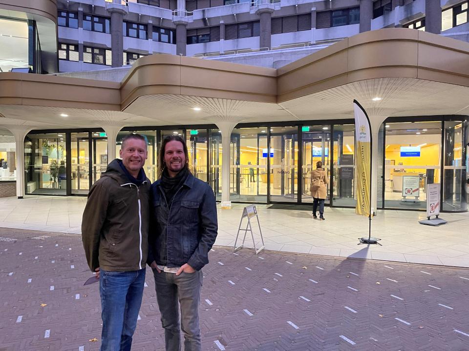 Twee personen, Steven en Benjamin, staan voor het gebouw van de Tweede Kamer, zij poseren voordat ze gaan stemmen. 