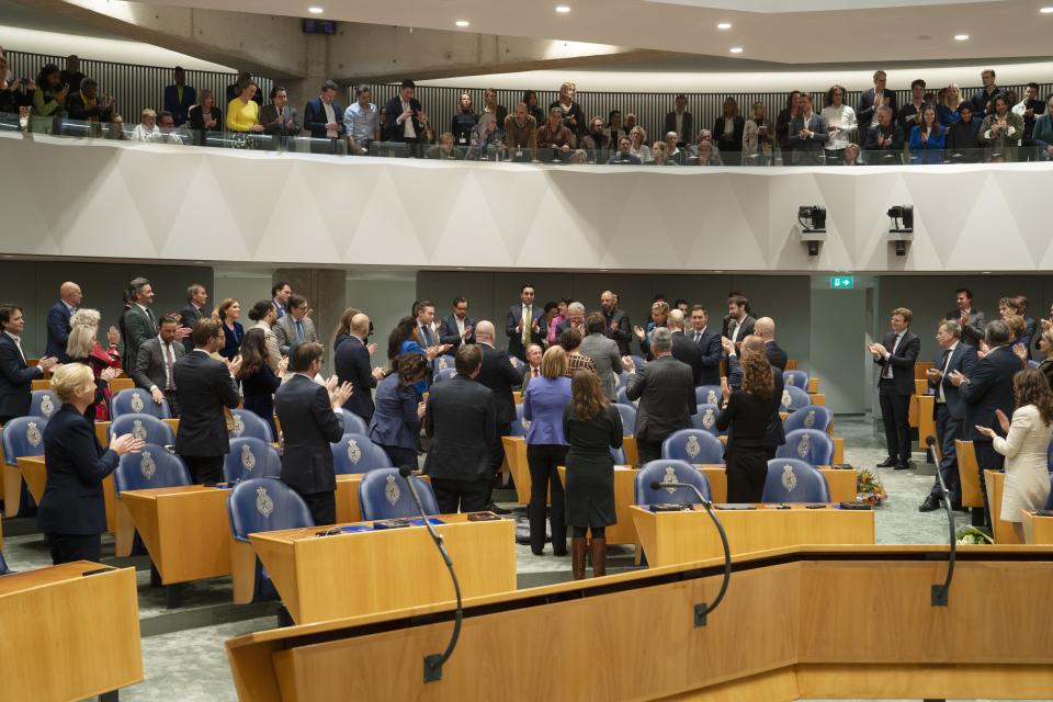 Kamerleden staan in de plenaire zaal en klappen bij het afscheid van Cees van der Staaij.