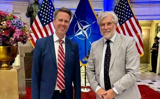 Kamervoorzitter Martin Bosma (links) en Griffier Peter Oskam staan voor een reeks Amerikaanse en NAVO-vlaggen. 
