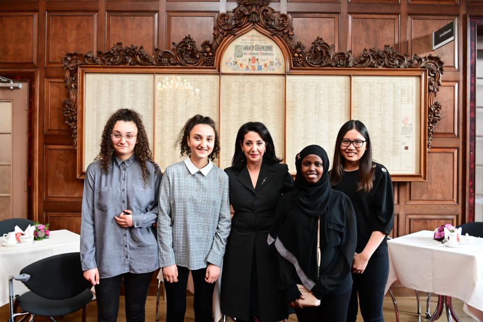 Voorzitter Khadija Arib met de scholieren die gedichten hebben voorgedragen bij de 4-mei-herdenking bij de Erelijst van Gevallenen