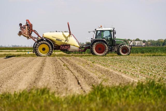 Tractor rijdend op landbouwgrond