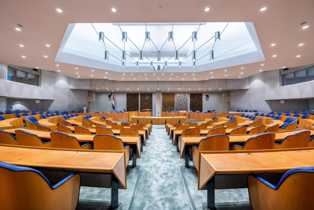 Lege plenaire zaal van de Tweede Kamer.