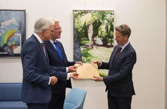 Informateurs Elbert Dijkgraaf en Richard van Zwol overhandigen een document aan Kamervoorzitter Martin Bosma in de Schrijfkamer van de Tweede Kamer.