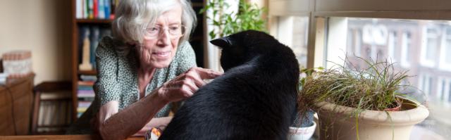 Een oudere vrouw met een kat